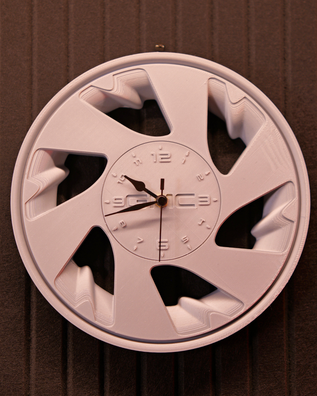 Close-up of Syclone style automotive wheel wall clock with spoke detail