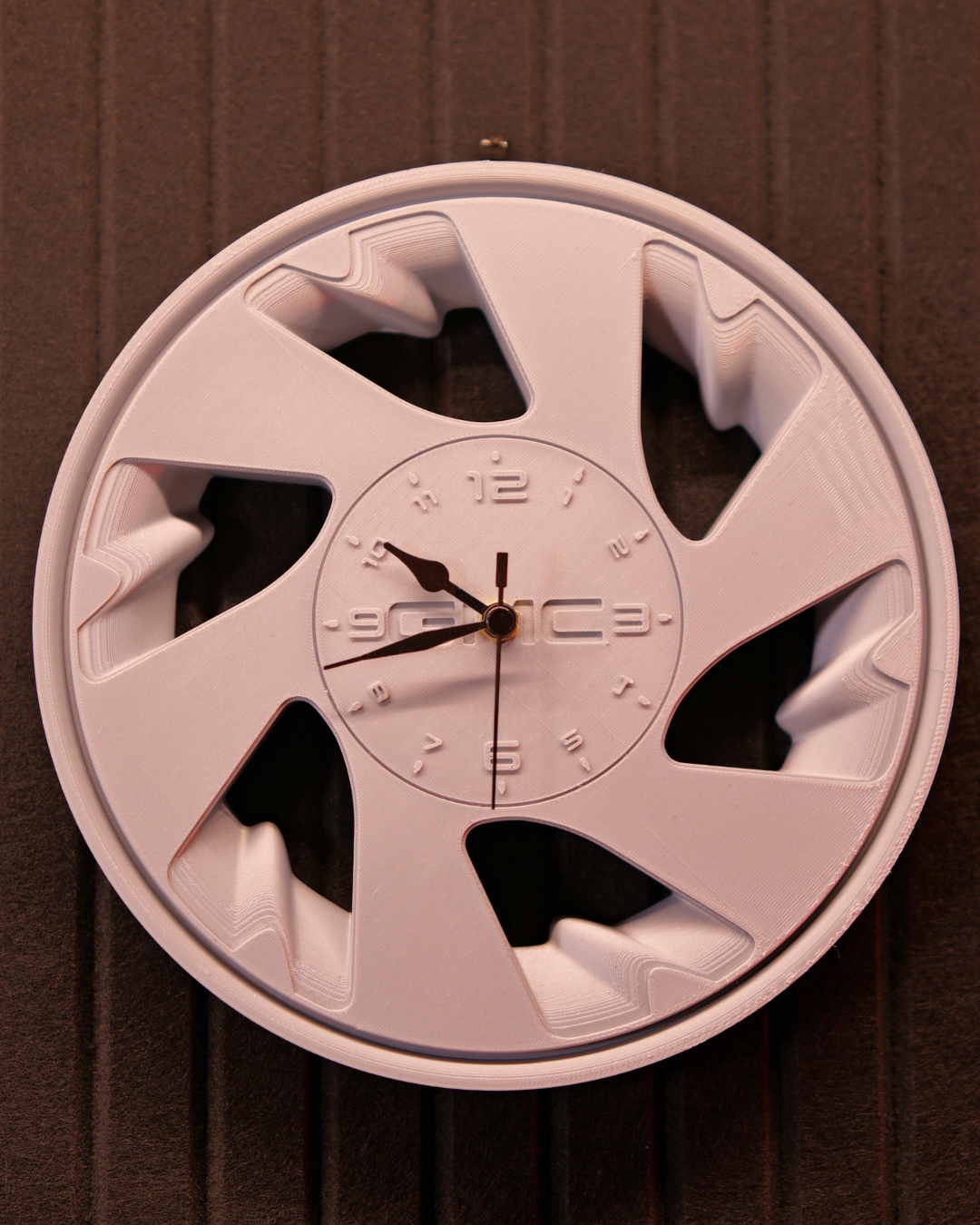 Close-up of Syclone style automotive wheel wall clock with spoke detail